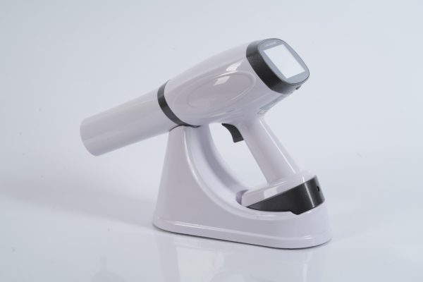 IDEN-X2 handheld dental X-ray unit with charging dock — touchscreen display visible